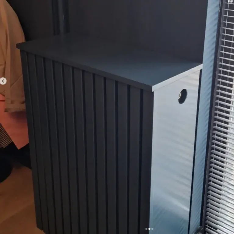 Een op maat gemaakte, donkergrijze radiatorombouw met verticale lamellen aan de voorkant en een gladde bovenplaat.